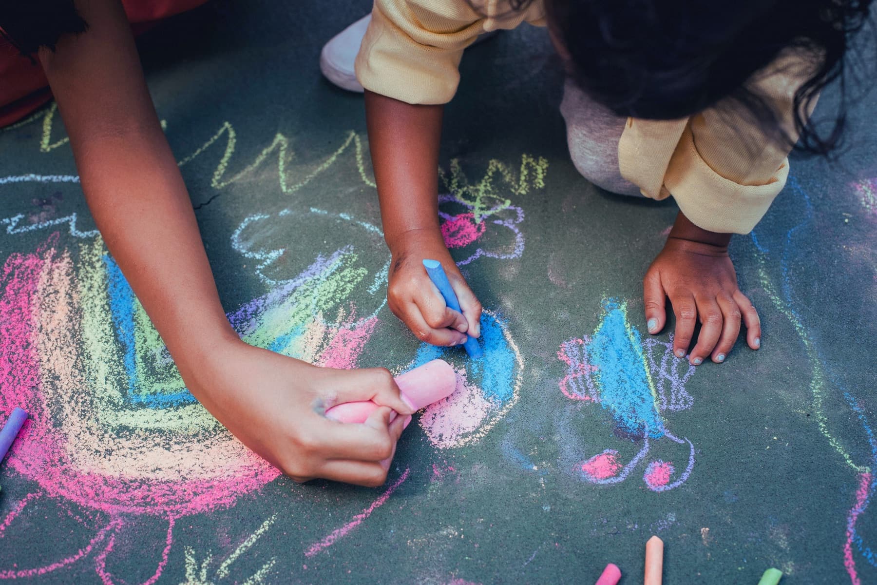 Children drawing together with sidewalk chalk
